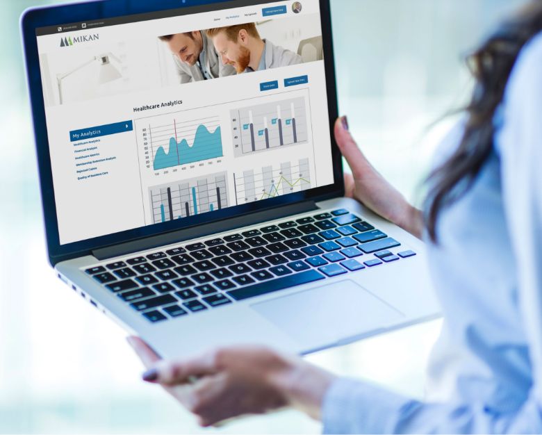 A woman working on a laptop displaying a business dashboard focused on membership renewal patterns.